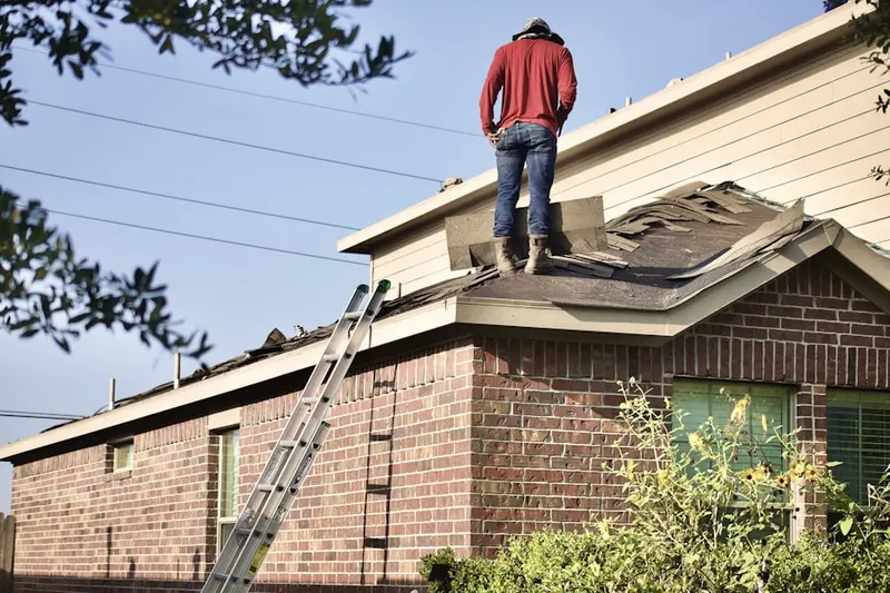 Professional roofer working on a residential roof in Clayton Hill II